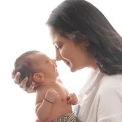 A tender moment between a mother and her newborn, captured in a high-key style that emphasizes their close bond and loving expressions.