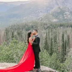 A close-up of the couple during their mountain pre-wedding shoot. The bride's red gown with its long train creates a beautiful, romantic image.