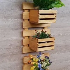 A simple yet elegant wall-mounted planter made from pinewood. This three-box design is ideal for creating a small herb garden or displaying colorful flowers in a compact area.