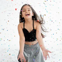 Pure joy looks like this! A confetti shower is the perfect way to end a fifth birthday photoshoot, capturing a moment of genuine laughter and celebration.