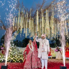 The couple stands united under a magnificent tree of life mandap, with cascading floral strings and celebratory cold pyros. This is the pinnacle of the celebration, a moment we craft to be truly unforgettable.