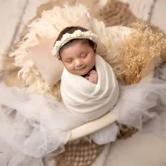 The pure, simple beauty of a newborn. This portrait captures a sweet, smiling newborn in a heart-shaped bowl, a symbol of all the love that surrounds them.