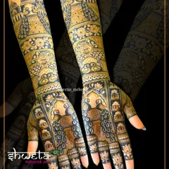 This design shows the beauty of a dark, rich henna stain. The bold peacock figures and architectural elements create a striking and traditional full-arm mehendi.