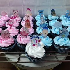 A closer look at my baby shower cupcakes. This set was for a gender reveal party, with pink and blue frosting and toppers like baby rattles, prams, and teddy bears.