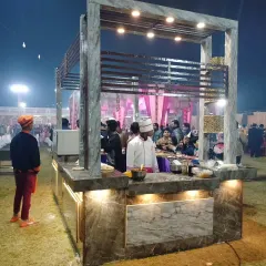 A wider view of the contemporary marble-finish live station, bustling with guests. The under-counter lighting adds a sophisticated glow to the setup.