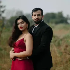 A classic portrait pose that feels both elegant and strong. The natural, earthy tones of the landscape complement their formal attire in this outdoor pre-wedding session.
