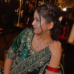 A side profile showing the soft glam makeup and romantic hairstyle. The half-updo with gentle waves is perfect for a party, keeping the hair off the face while still looking elegant.