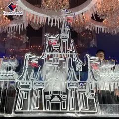 Another view of the intricate castle ice sculpture, highlighting the detailed craftsmanship. These sculptures can be designed to hold bottles, serve drinks, or simply stand as a stunning decorative element.