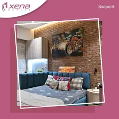 Another bedroom with an industrial feel, this space features a brick-textured wall and a motorcycle-themed artwork. The custom bed with a blue channel-tufted headboard adds a pop of color and comfort.