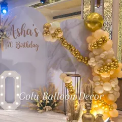 A closer look at the balloon decor for the 70th milestone party. The arch combines cream and chrome gold balloons in various sizes for a rich, textured look against the marble-effect backdrop.