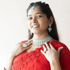A happy client looking radiant in our silver-plated AD choker set. She has paired it with a red saree, creating a classic and glamorous look for her event.