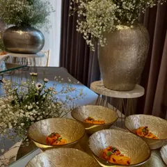 A beautifully styled buffet table for an anniversary, featuring our Spicy Pizza Paneer Paprika Dip and other dishes, framed by elegant silver vases of baby's breath.