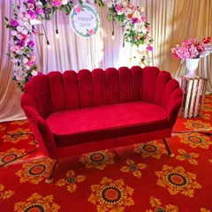 A close-up of the elegant red velvet sofa I provide for event seating. It adds a touch of luxury and provides a beautiful focal point for photos, especially when paired with a floral arch.