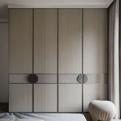 A sophisticated wardrobe design featuring textured, fabric-like laminate doors with sleek metal inlays and unique circular handles. This piece acts as a statement feature in the bedroom, blending modern design with tactile materials.