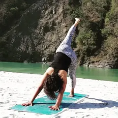 A one-legged downward dog stretch by the river. This variation, Eka Pada Adho Mukha Svanasana, opens the hips and lengthens the hamstrings while building upper body strength.