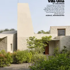 A view of Villa Uma, tucked off a gravel road in the village of Satirje. The home's unique form, with its prominent light tower, creates a distinctive silhouette against the lush Alibaug landscape.