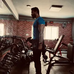 Performing a dumbbell curl with strict form. Focusing on the mind-muscle connection is crucial for hypertrophy and getting the most out of every repetition.