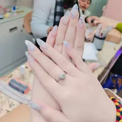 An elegant and icy look created with long, tapered nail extensions and a dense silver glitter gradient. This is a perfect example of a sophisticated party or wedding nail design.