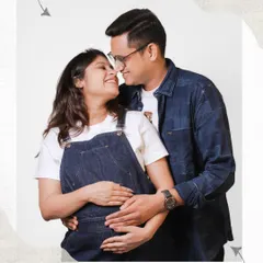 The journey to becoming a family is a story in itself. This casual and happy maternity portrait captures the excitement and love between a couple as they anticipate their new arrival, set against a simple, clean backdrop.