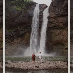A breathtaking wide shot of a couple standing before a massive waterfall. This photo captures the scale and power of nature, making for an epic pre-wedding picture.