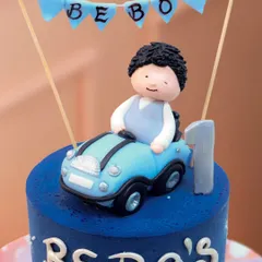 A close-up of the handcrafted topper, showing the little boy, the "Bebo" banner, and the number one.