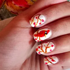 An example of hand-painted nail art. This charming "winter berries" design with a cardinal bird shows the level of detail and creativity we explore in my nail art workshops.