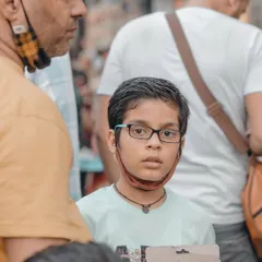 A young boy's curious expression caught in the middle of a crowd. Learning to anticipate moments and be ready to shoot is a core skill in street photography that we will practice together.