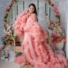 A playful pose in our popular pink ruffled gown and floral arch setup.