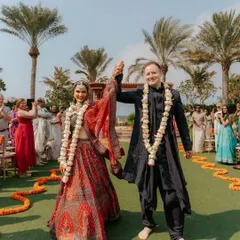 The "just married" walk. The couple's triumphant hand-in-hand walk down the aisle after the ceremony, surrounded by cheering guests and a beautiful outdoor setting.