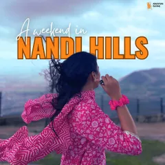 A traveler enjoying the windy morning at Nandi Hills. This popular one-day trip from Bangalore is perfect for catching a beautiful sunrise above the clouds.