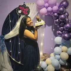 The bride-to-be holding up her cake in front of the beautiful balloon arch. This is a perfect spot for taking photos before everyone digs in.