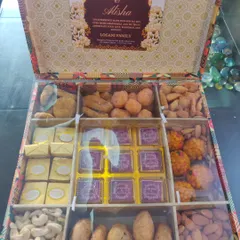 For a truly traditional touch, I designed this custom 'bhaji box' for a client's family. It's a modern take on a classic wedding tradition, with organized compartments for Indian sweets, assorted dry fruits, and chocolates personalized with the couple's names, Harsh and Alisha.