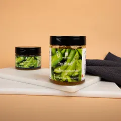 Jars of Green Chilli Stuffed Pickle styled on a marble board with a dark cloth, providing a rustic and authentic feel.