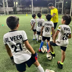 A coach gives tactical instructions to our U10 team. We focus on developing game intelligence, positioning, and a deeper understanding of strategy.