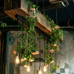 This rustic-chic chandelier uses a wooden beam as its base, with ivy and soft pink flowers woven around hanging bulbs. It's a perfect fusion of industrial and botanical styles.