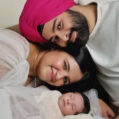A creative overhead shot that brings the whole family together. This pose creates a sense of closeness and intimacy, beautifully framing the newborn at the center of their new world.