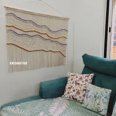 Here is a large 4-foot by 3.5-foot macraweave wall hanging I created, seen here in its new home. The client wanted specific shades of purple and mustard woven in, and I love how the colors pop against the natural cotton. This is a great way to add texture and a personal touch to your living room.