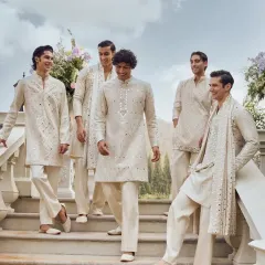 A group of happy groomsmen dressed in identical ivory mirror-work kurtas for a Haldi ceremony. This creates fantastic photo opportunities and a memorable look for your wedding album.