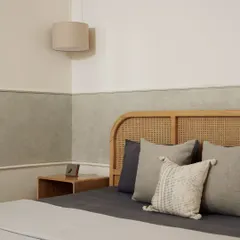 This bedroom embodies the essence of Japandi design, blending the simplicity of Japanese minimalism with Scandinavian warmth. The rattan headboard, textured lime-wash wall, and soft, neutral bedding come together to create a sanctuary of calm.