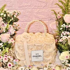 A little Coco and a little couture. Our Chanel bag cake, surrounded by a bed of fresh flowers, is the ultimate luxury centerpiece.