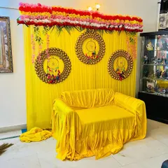 This image shows the full view of the home function backdrop. The top is lined with rows of fresh flowers, and hanging floral strings are added on the sides for a complete look.