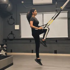 Using the TRX suspension trainer for a knee-tuck exercise. This move is fantastic for building core strength and stability.