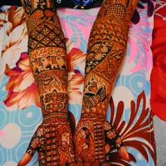 A unique bridal design combining multiple stories. It features couple portraits, traditional elephant motifs, and scenes from the wedding ceremony, all woven together in a full-arm design.