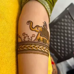 A simple yet elegant elephant motif on the upper arm. This is a great option for someone who wants a touch of figurative art without a full bridal design.