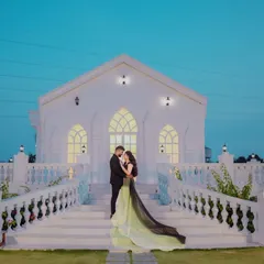 The long, dual-toned train of this gown drapes elegantly down the steps of this beautiful white chapel, creating a striking visual for a pre-wedding shoot.