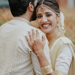 A tender moment captured from behind the groom. Aishwarya's radiant smile shines as she hugs Adithya during their traditional Kerala wedding.