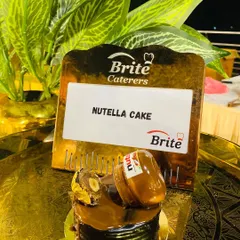An individual Nutella Cake, topped with a miniature Nutella jar and a Ferrero Rocher.