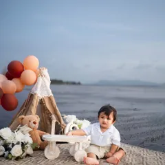 A quiet moment by the sea, with a little boy and his wooden tricycle. Outdoor sessions allow for beautiful, expansive portraits with a sense of freedom.