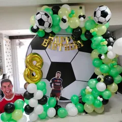 For the young football fan, this setup includes a giant football backdrop, a green, black, and white balloon arch, and cutouts of star players.