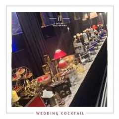 A beautifully arranged buffet for a wedding cocktail party. The setup features elegant decor with red accents and a variety of dishes to suit every palate.